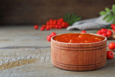 Delicious rowan jam in wooden bowl on table. Space for text