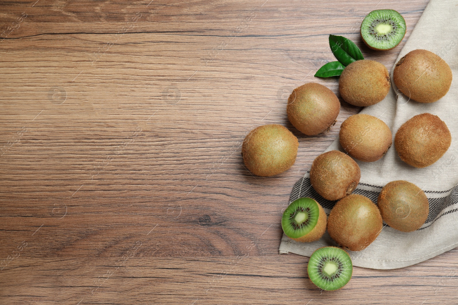 Photo of Fresh ripe kiwis on wooden table, flat lay. Space for text