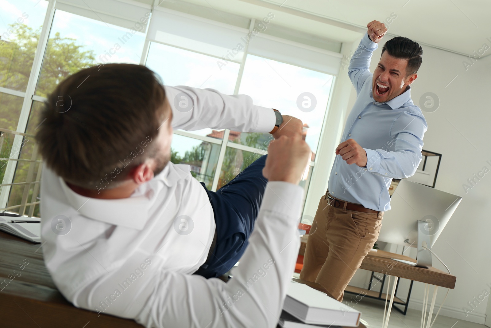 Photo of Emotional colleagues fighting in office. Workplace conflict