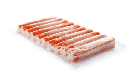 Photo of Delicious crab sticks in plastic packaging isolated on white