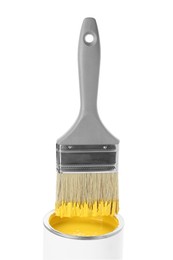 Brush with yellow paint over can isolated on white