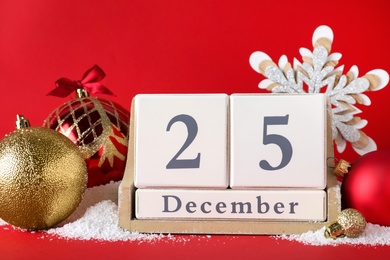 Photo of Block calendar and festive decor on red background. Christmas countdown