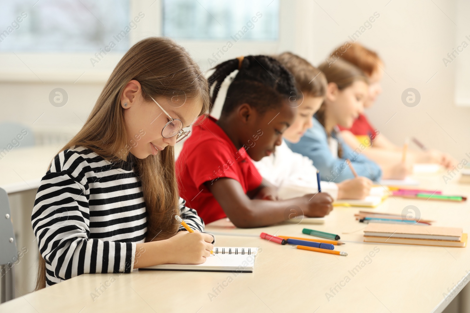 Photo of Cute children studying in classroom at school