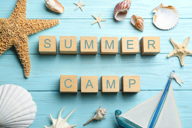 Flat lay composition with phrase SUMMER CAMP made of cubes on light blue wooden background