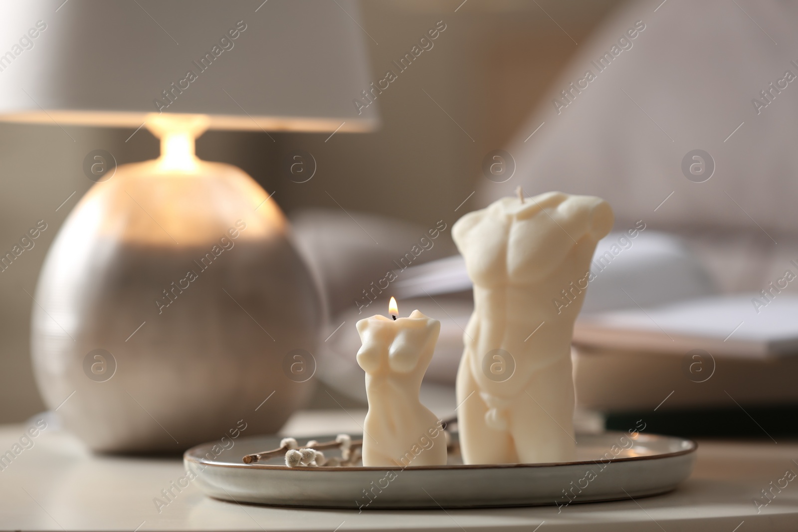 Photo of Beautiful body shaped candles on table indoors