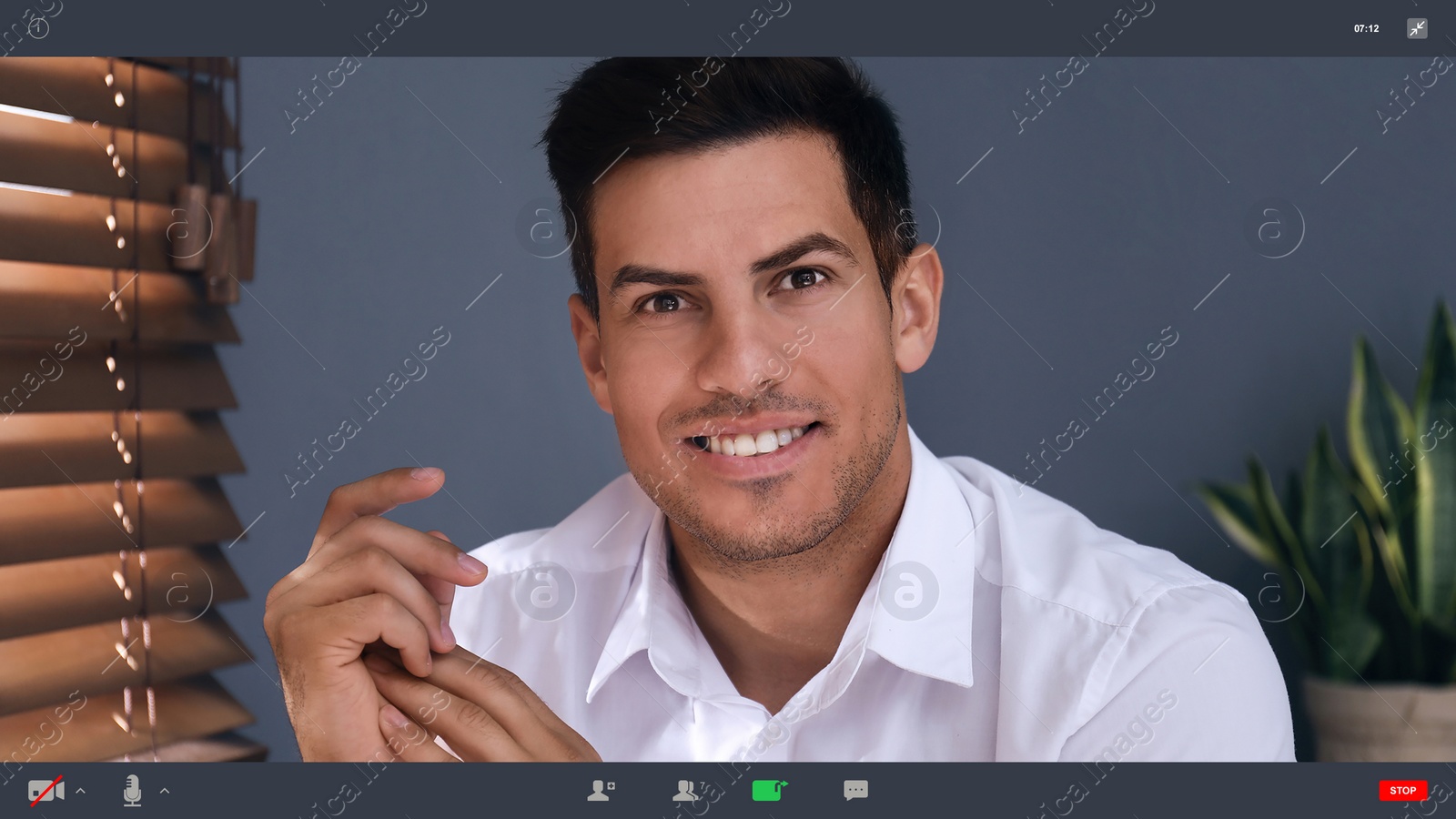 Image of Man communicating with coworkers from home using video chat, view through camera