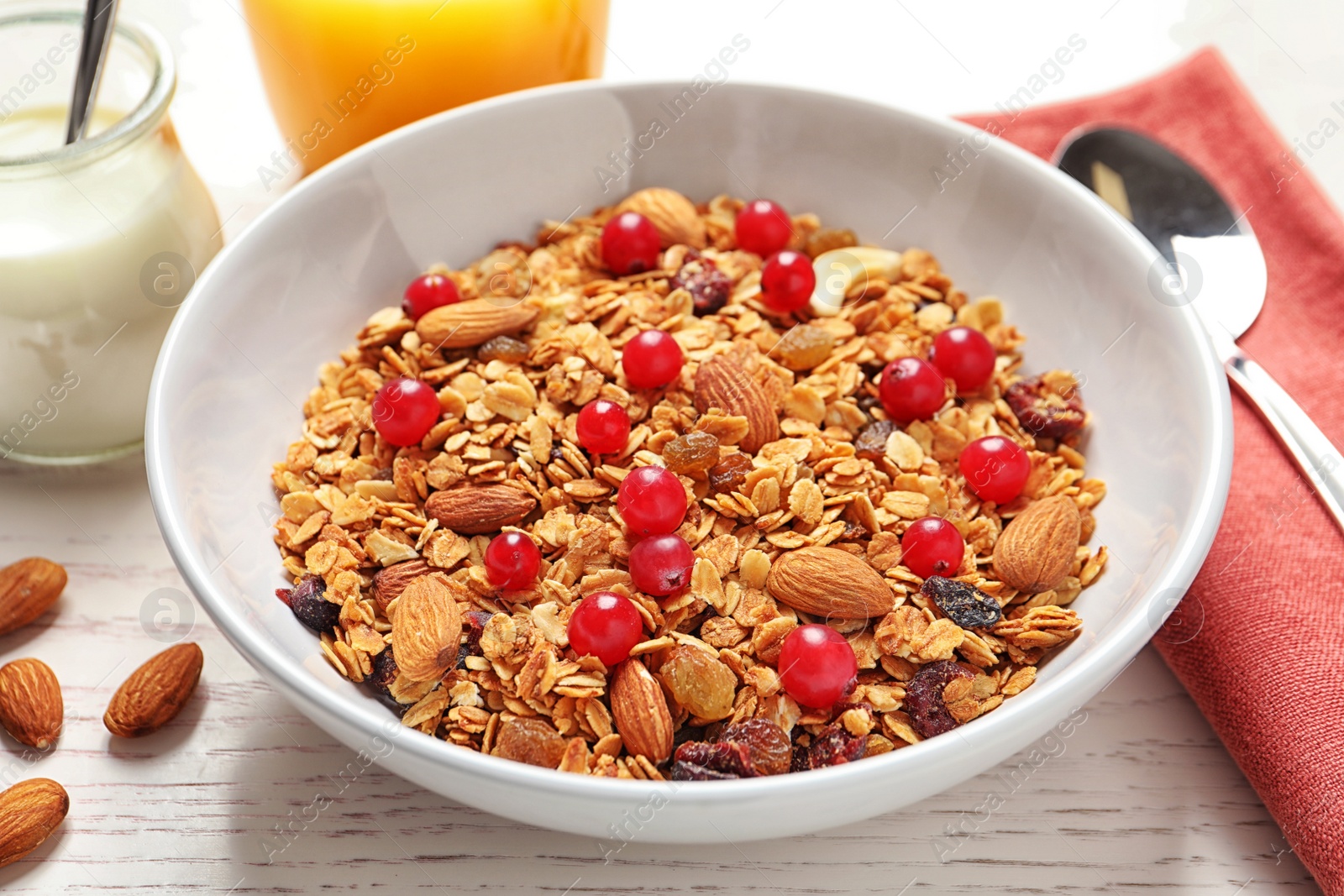 Photo of Tasty granola with cranberries on white wooden table, closeup. Healthy breakfast