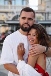 Photo of Happy young couple hugging on city street