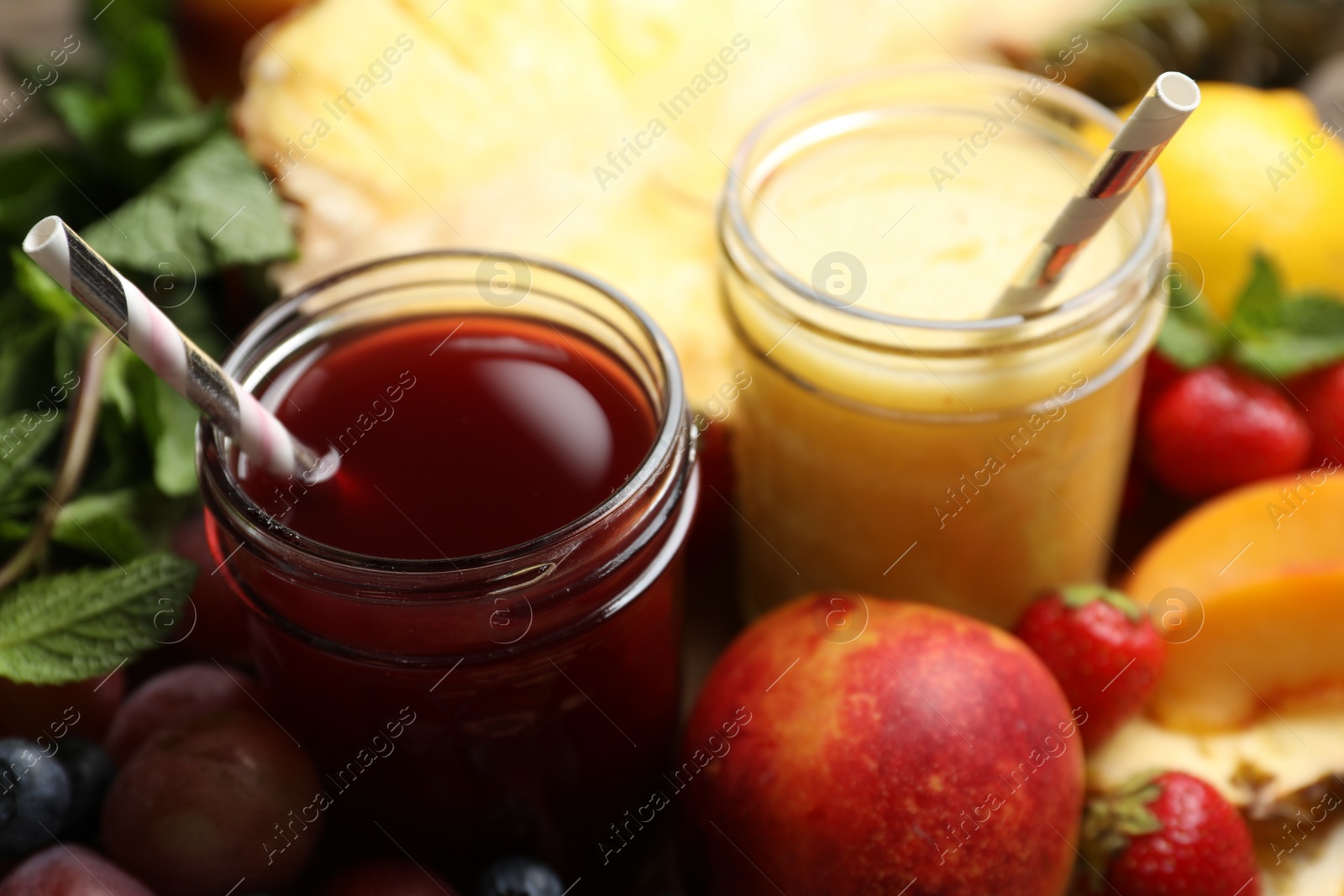 Photo of Delicious colorful juices in glasses and fresh ingredients on table, closeup