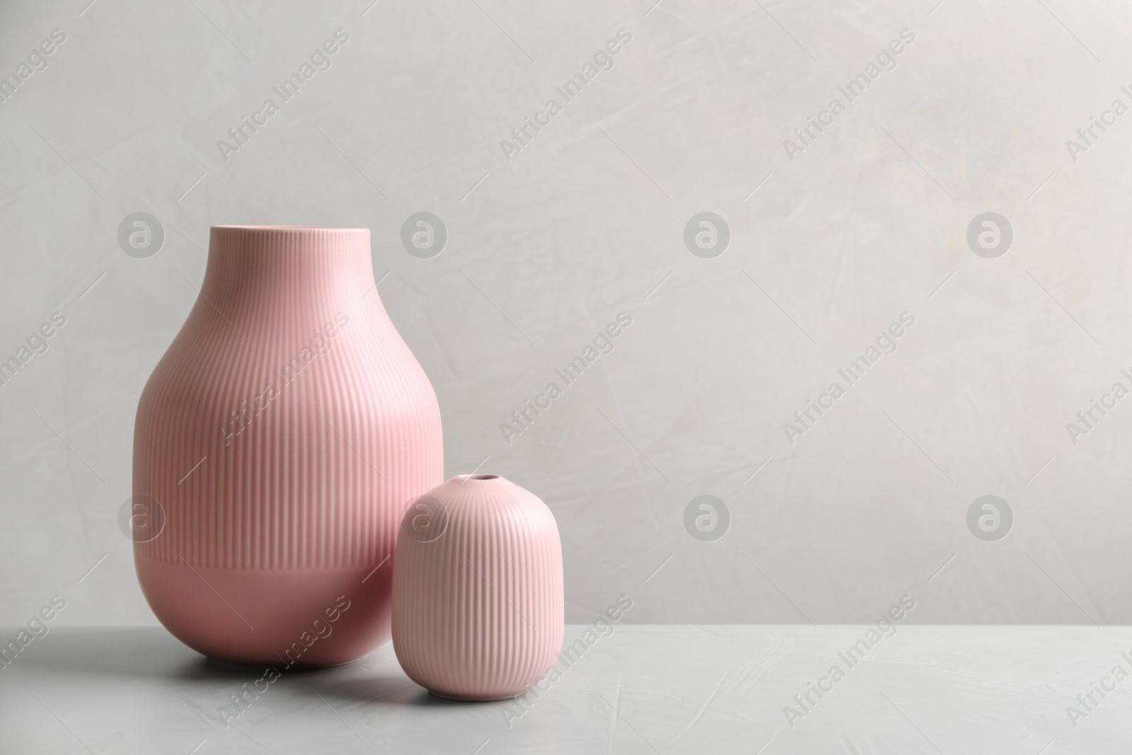 Photo of Stylish ceramic vases on grey stone table. Space for text