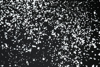 Photo of White snow falling down on black background