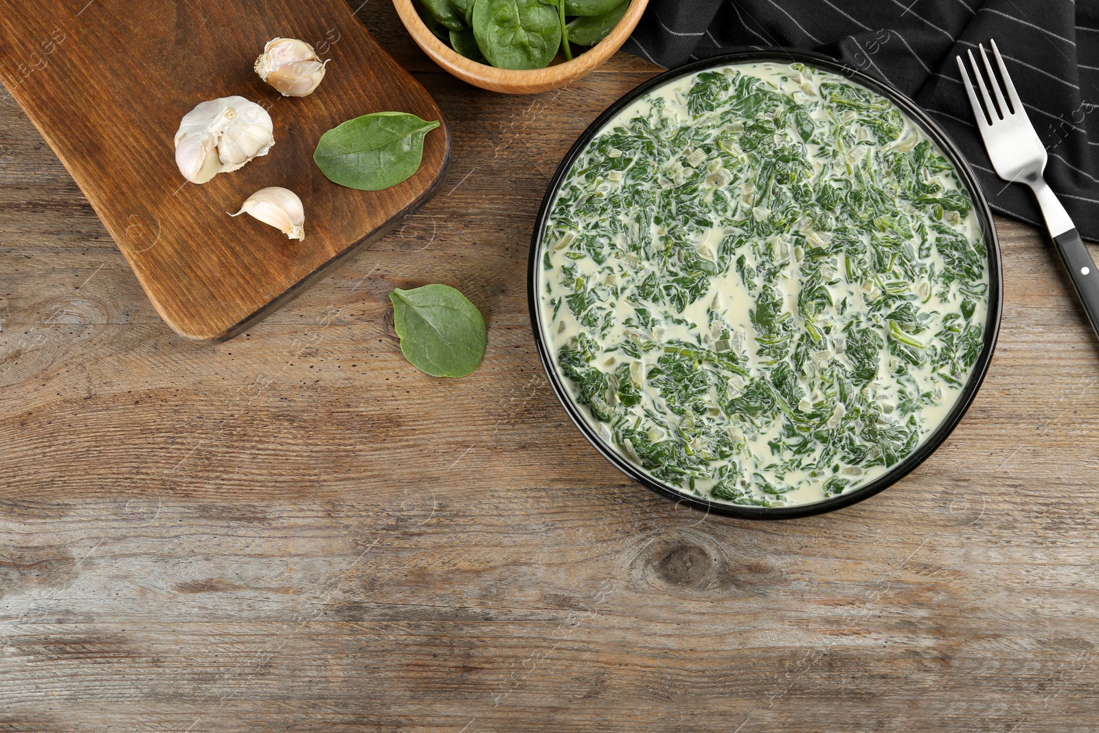 Photo of Tasty spinach dip on wooden table, flat lay