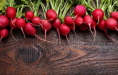 Photo of Fresh ripe radish on wooden table, space for text