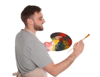 Photo of Man painting with brush on white background. Young artist