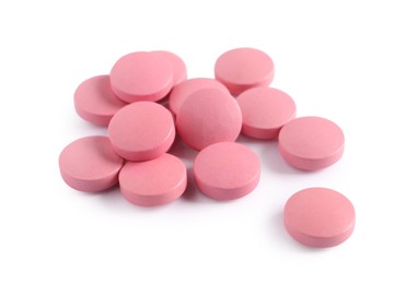 Photo of Pile of pink pills on white background