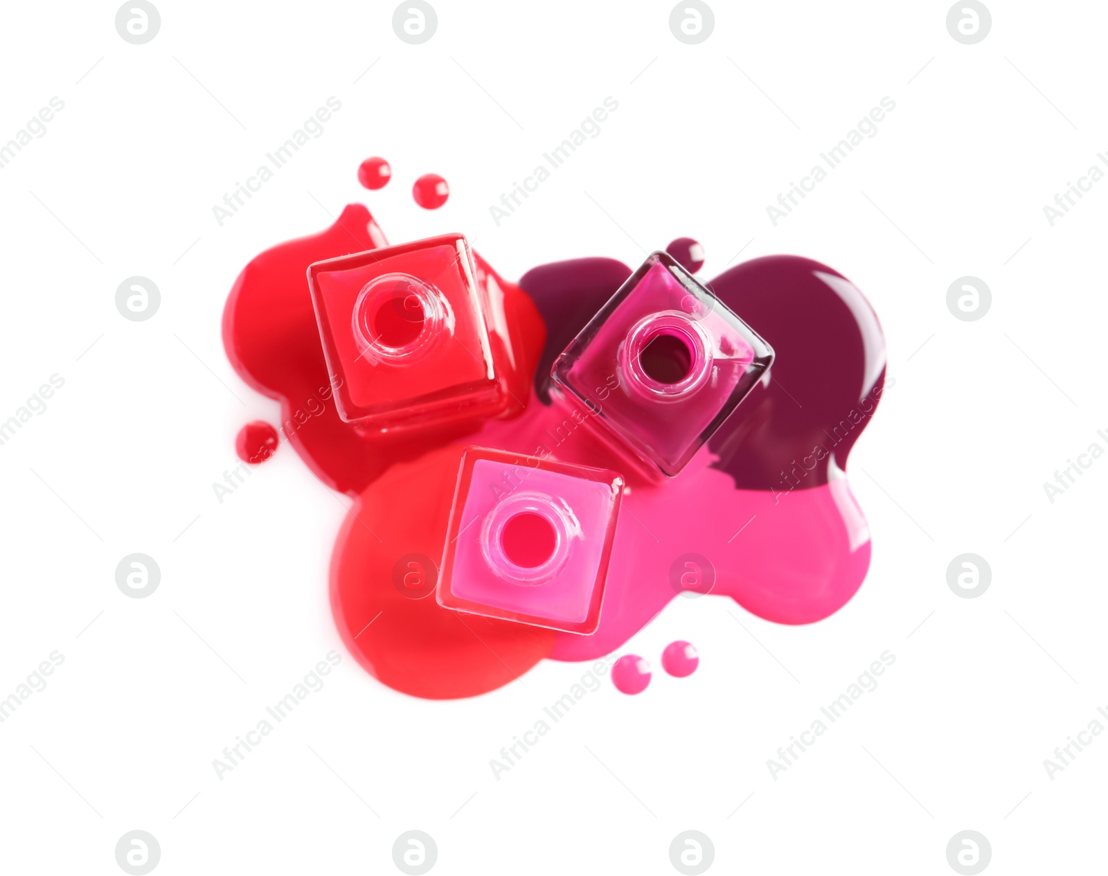 Photo of Spilled different nail polishes with bottles on white background, top view