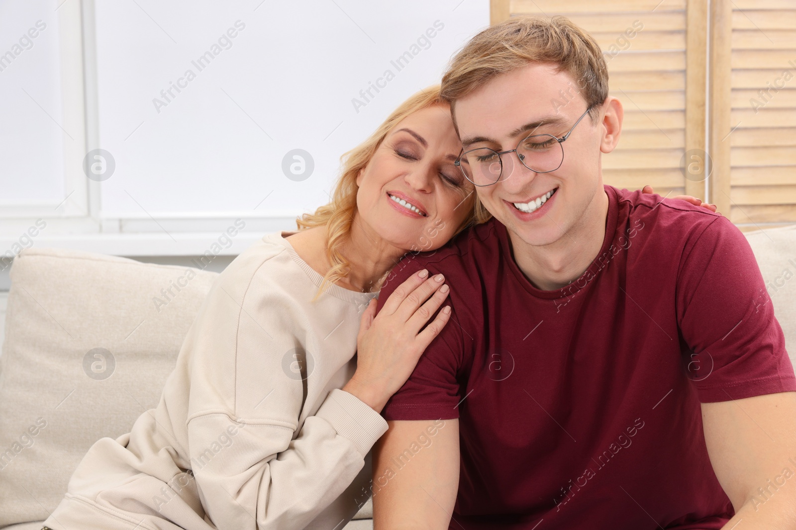 Photo of Mother and son spending time together on sofa at home. Family bonding