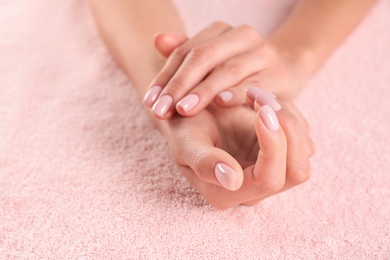 Photo of Closeup view of beautiful female hands on towel, space for text. Spa treatment