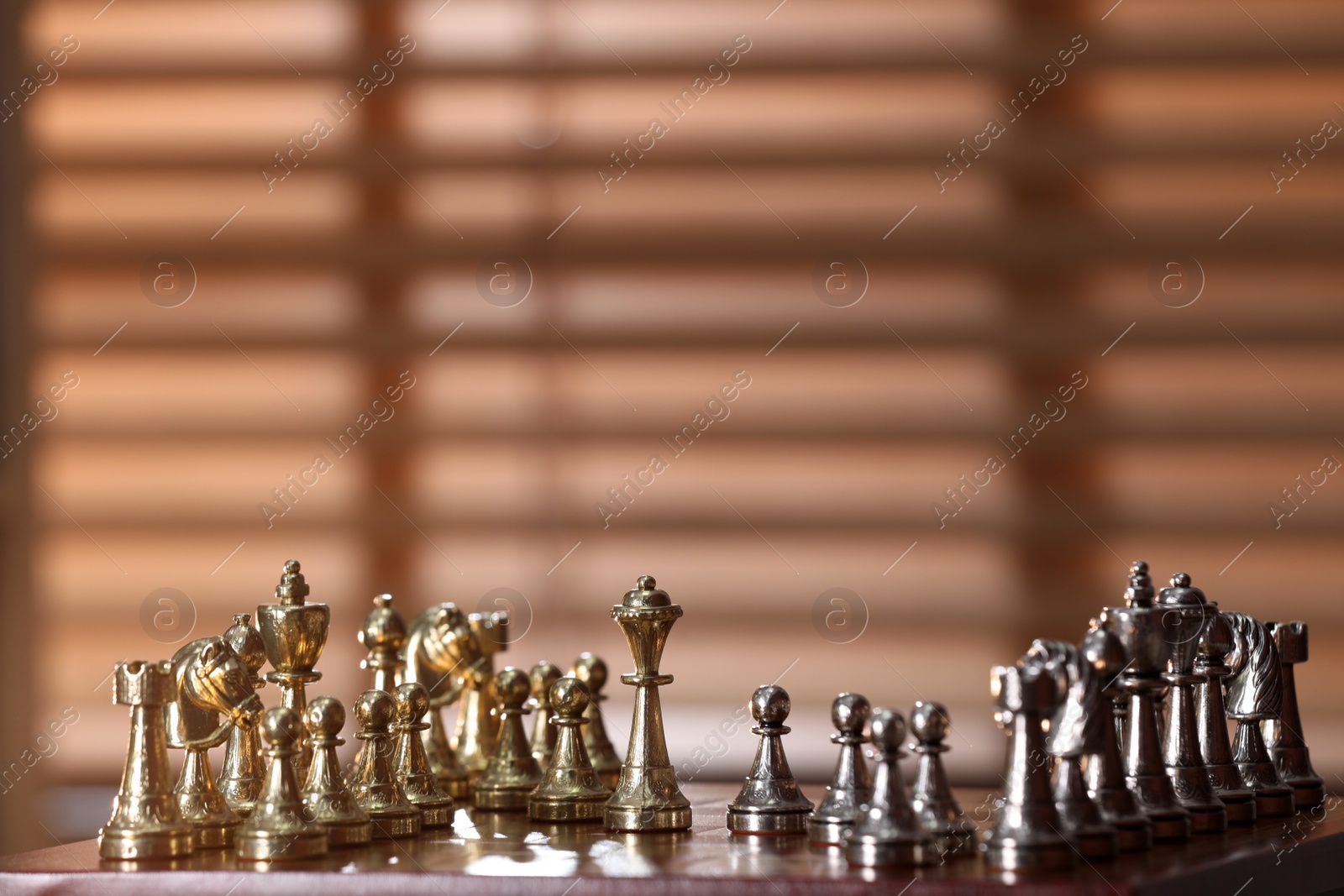 Photo of Chessboard with game pieces near window indoors, space for text