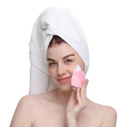 Young woman washing face with brush and cleansing foam on white background