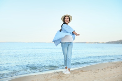 Photo of Beautiful young woman in casual outfit on beach