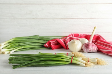 Photo of Bunches of green onions on white wooden table