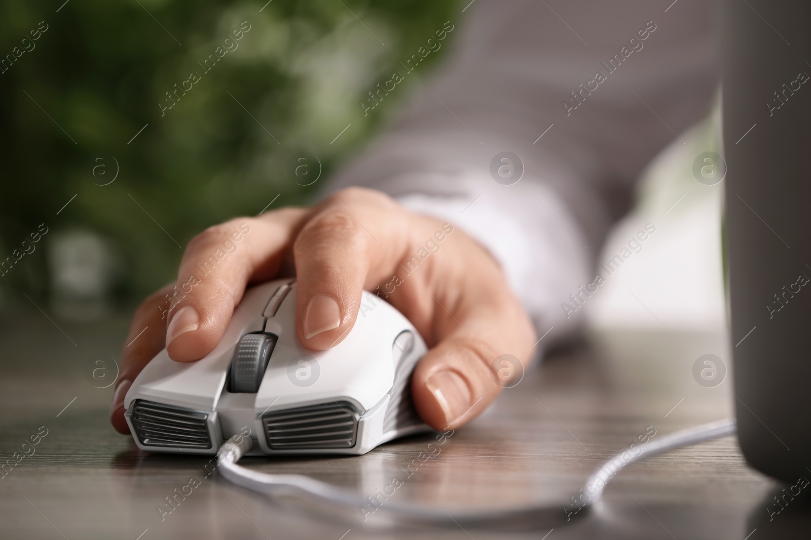 Photo of Woman using computer mouse with laptop at table, closeup