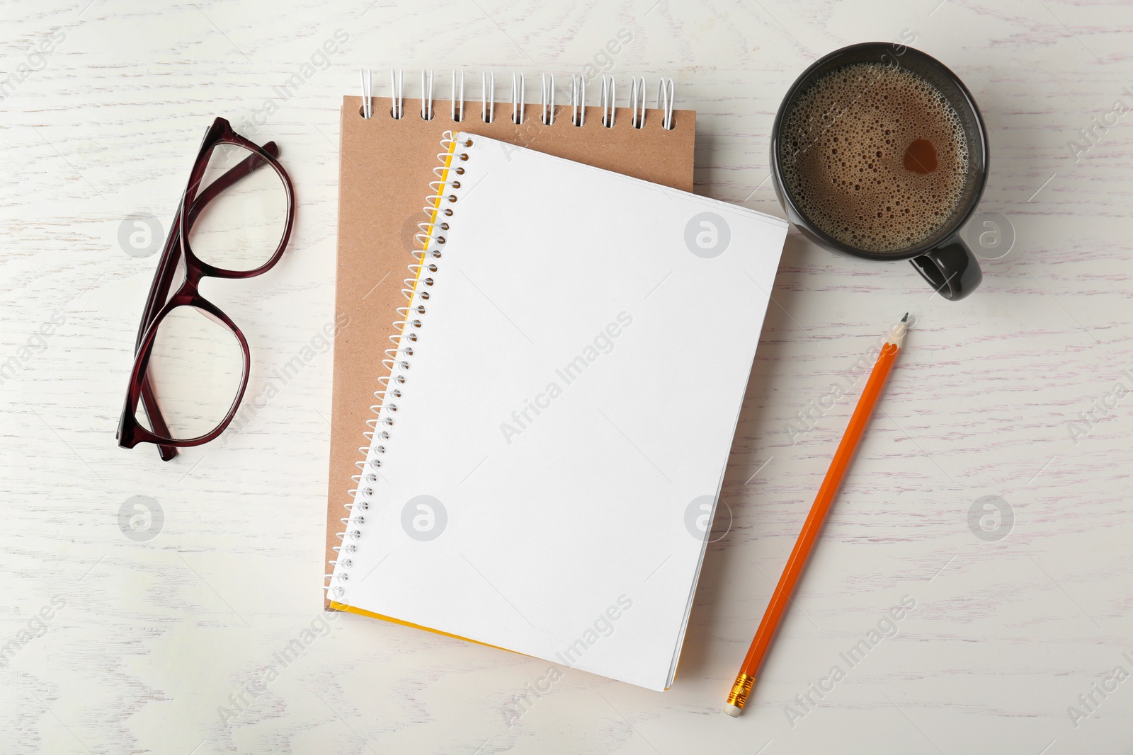 Photo of Flat lay composition with office stationery and cup of coffee on white wooden table. Space for design