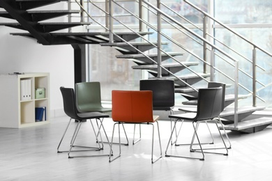 Photo of Chairs prepared for group therapy session in office. Meeting room interior