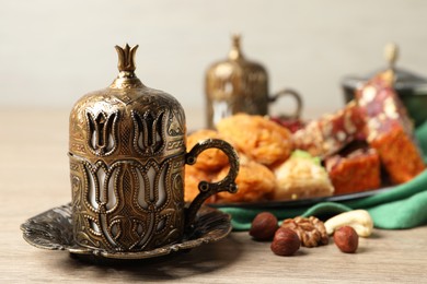 Photo of Tea, baklava dessert, nuts and Turkish delight served in vintage tea set on wooden table. Space for text