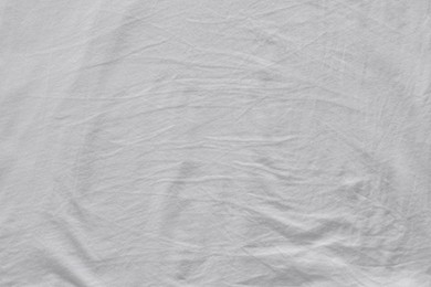 Photo of Crumpled white fabric as background, top view