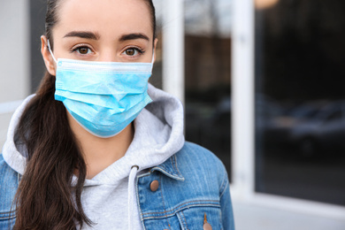 Photo of Woman wearing disposable mask outdoors. Dangerous virus