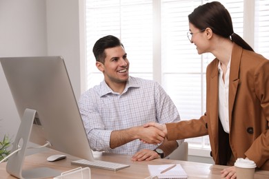 Photo of Employee shaking hands with intern in office