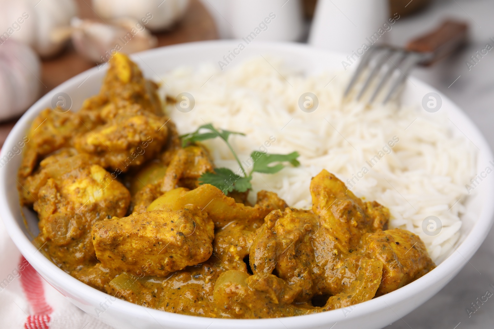 Photo of Delicious chicken curry with rice on table, closeup