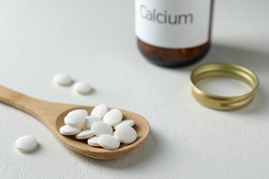 Photo of Calcium supplement pills on white table, closeup