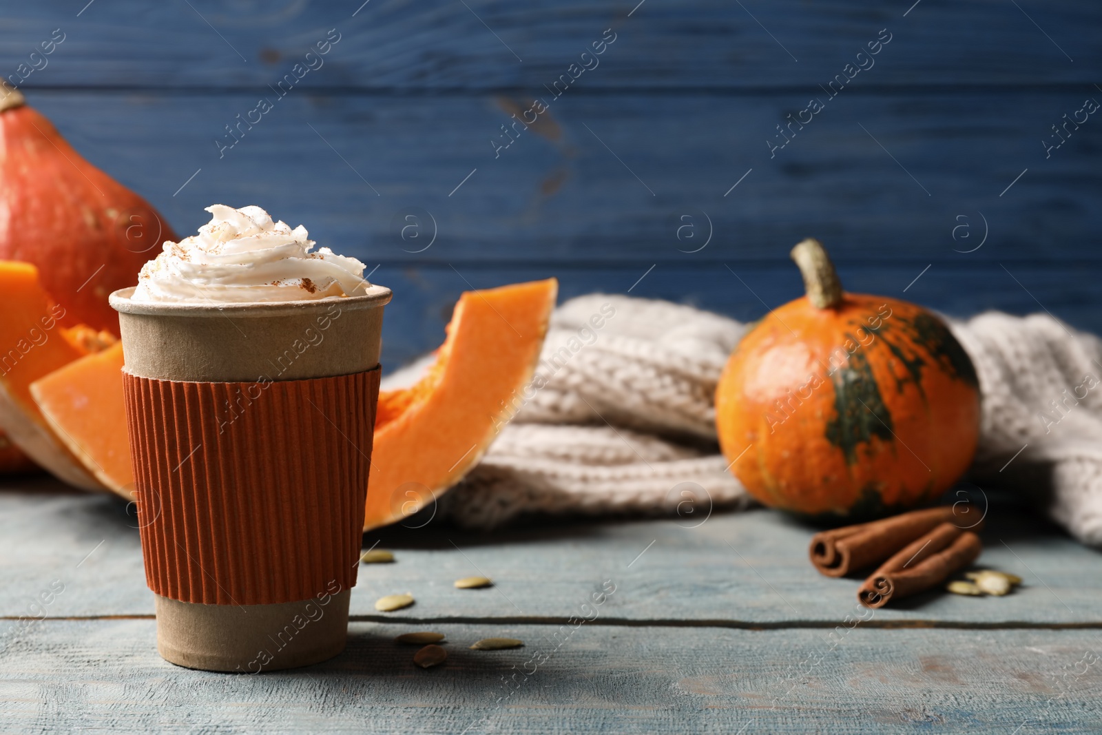 Photo of Cup with tasty pumpkin spice latte on wooden table