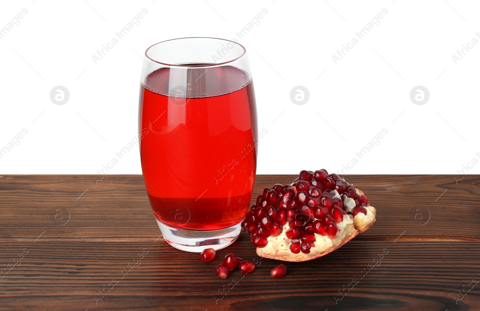 Photo of Refreshing pomegranate juice in glass and seeds on wooden table against white background