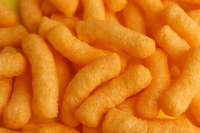 Photo of Tasty cheesy corn puffs as background, closeup