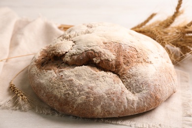 Tasty freshly baked bread on white wooden table, closeup