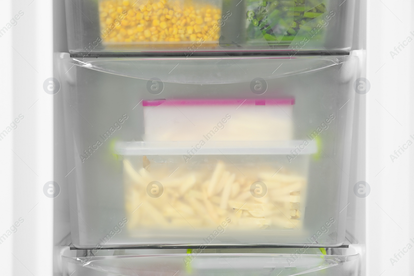 Photo of Containers with frozen vegetables in refrigerator, closeup