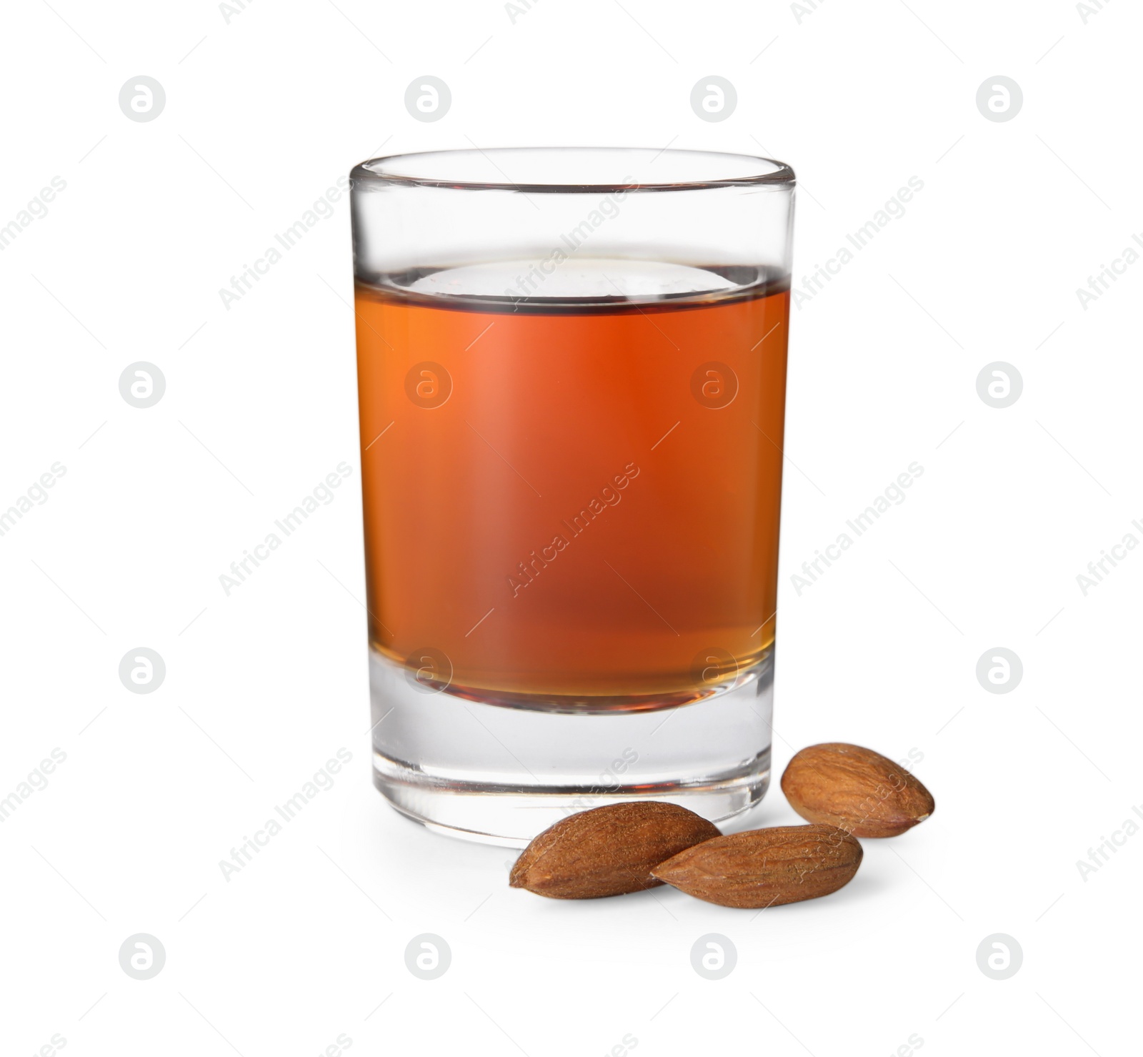 Photo of Shot glass with tasty amaretto liqueur and almonds isolated on white