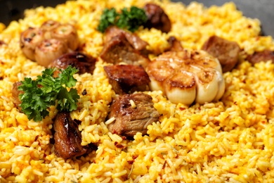 Delicious rice pilaf with meat as background, closeup