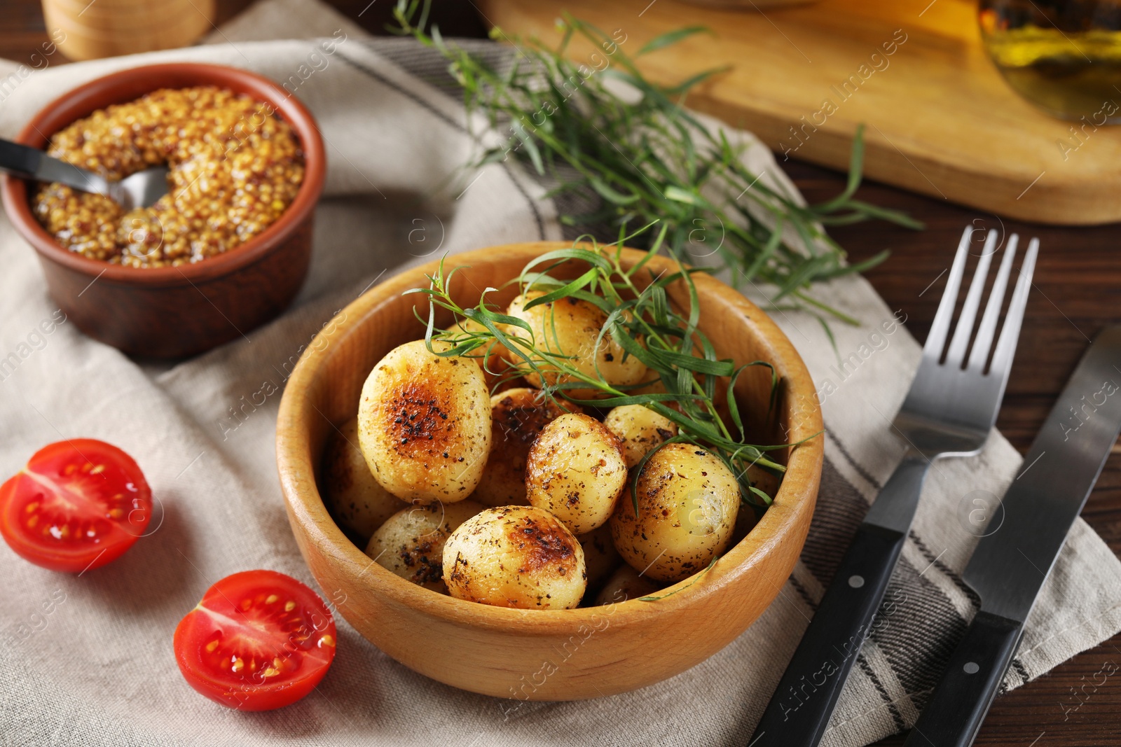 Photo of Delicious grilled potatoes with tarragon served on table