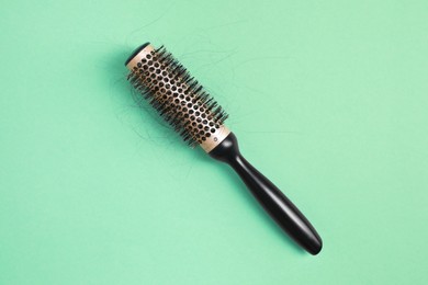 Professional brush with lost hair on green background, top view