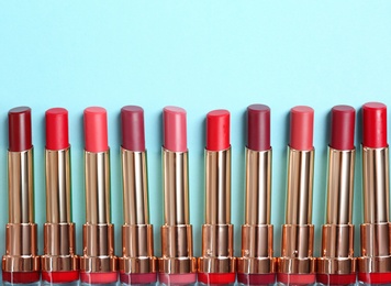 Flat lay composition with different stylish lipsticks on color background