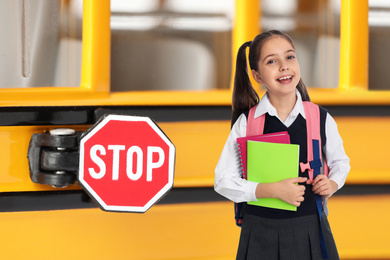 Image of Girl with backpack near yellow school bus. Transport for students