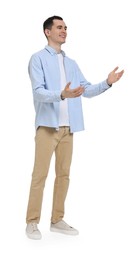 Young man in light blue shirt and beige pants on white background