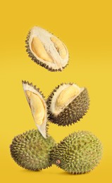 Image of Fresh ripe durians falling on yellow background