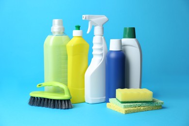 Cleaning supplies and tools on light blue background