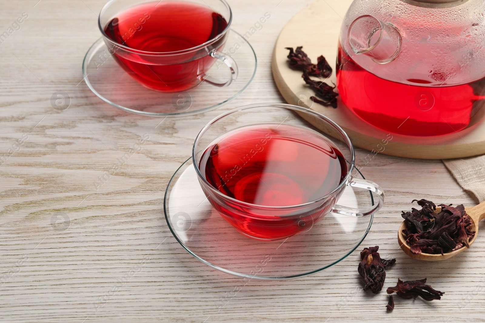 Photo of Fresh hibiscus tea and dry flower leaves on wooden table